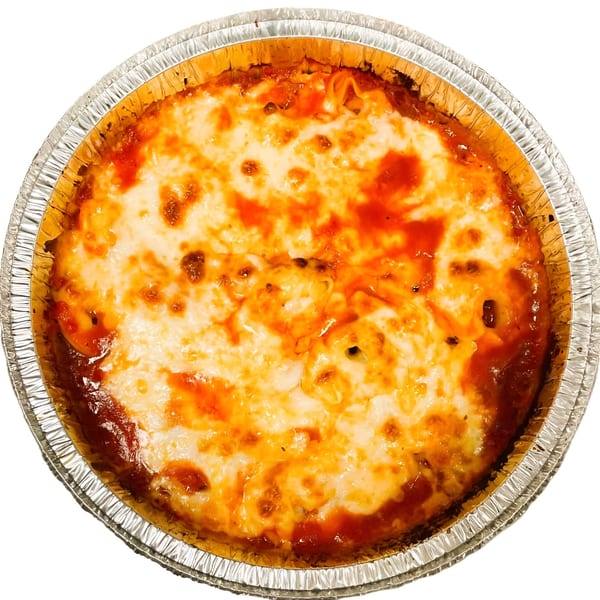 Baked spaghetti with melted cheese and tomato sauce in a round aluminum foil pan.